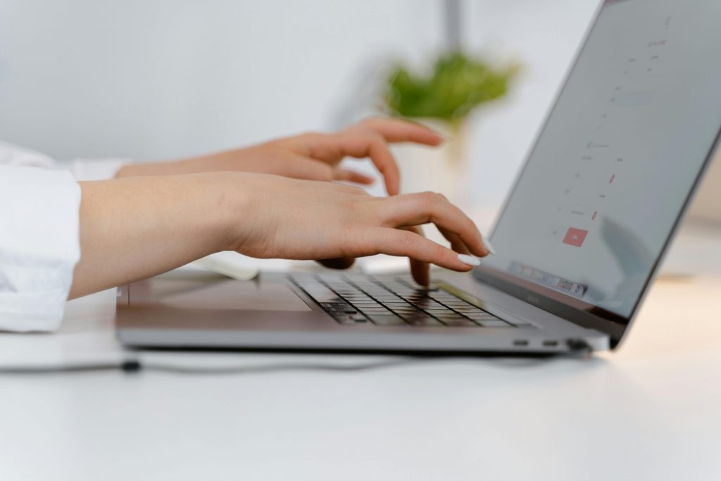 Person am Laptop und mit Belegen – moderne Buchhaltung im digitalen Zeitalter